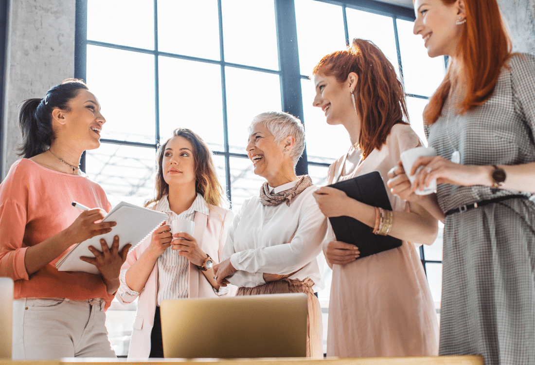 A group of female managers of different ages enhancing their teamship with help from a business consultancy agent focused on building leadership for inclusion.