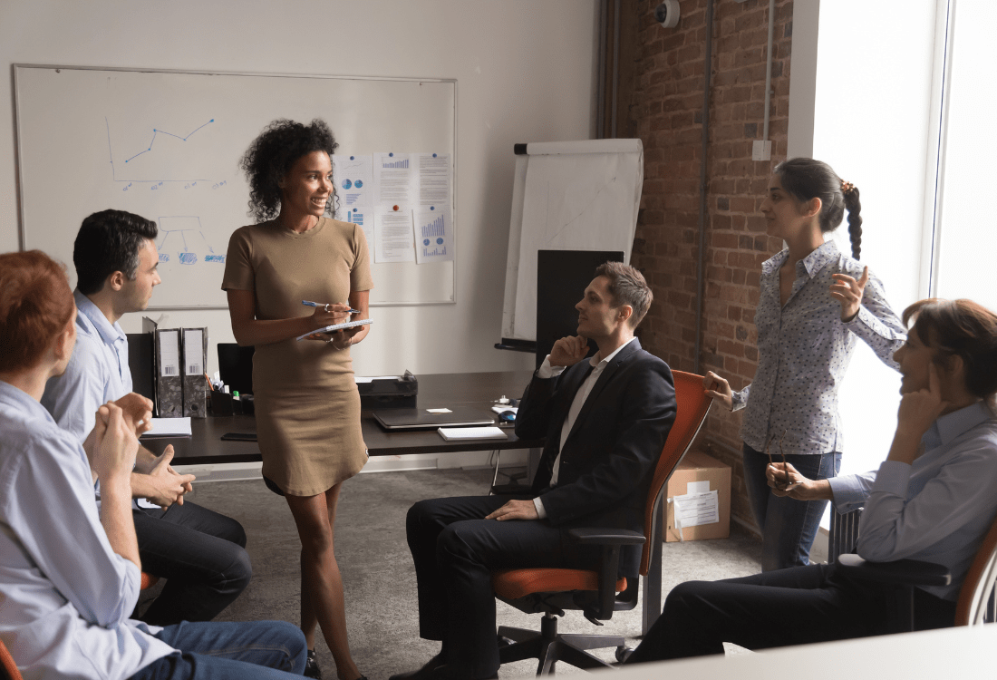 A leadership coach conducting c suite leadership training with a group of executives in an office. 